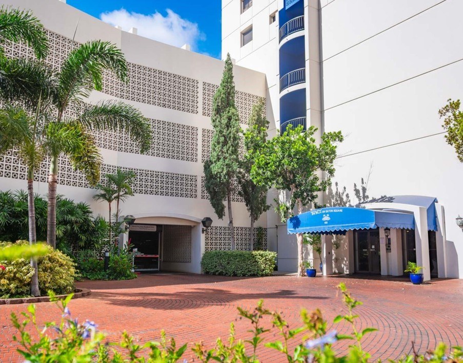 A building with a blue awning and a white wall with a pattern on it.